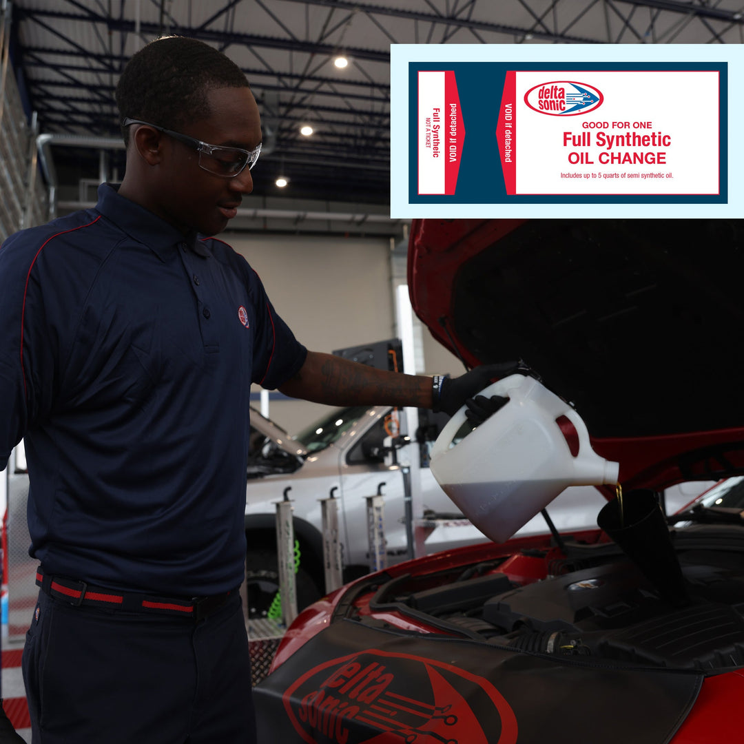 Delta Sonic employee pouring full synthetic oil into car.