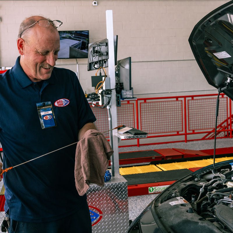 Delta Sonic employee performing full synthetic oil change